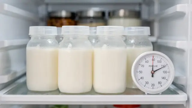 Muttermilch im Kühlschrank in beschriftungsfreien Behältern neben einem Thermometer