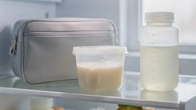 Aufgetaute Muttermilch in einem Küchensetting mit Aufbewahrungsflasche und Kühlschrank