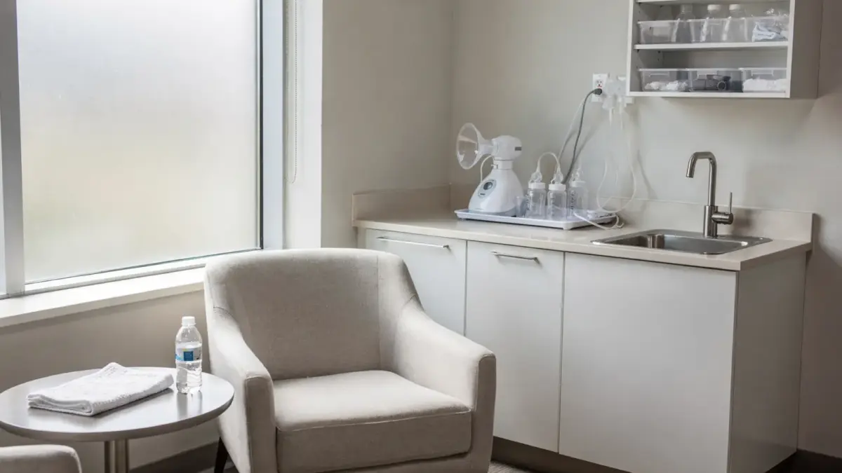 Abpumpraum am Arbeitsplatz mit Stuhl, Tisch und Milchpumpe in einer neutralen Büroumgebung