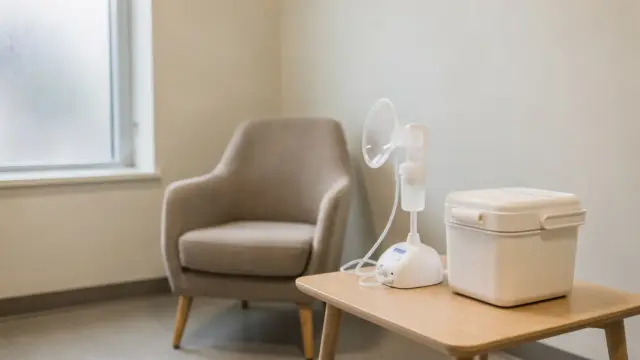 Abpumpen im Job: Brustpumpe und Milchbehälter in einem ruhigen Stillraum im Büro